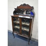 A 20TH CENTURY MAHOGANY DISPLAY CABINET, the raised top with a shelf, bevelled mirror back, above