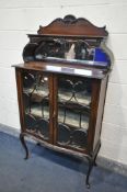 A 20TH CENTURY MAHOGANY DISPLAY CABINET, the raised top with a shelf, bevelled mirror back, above