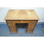 A GEORGIAN MAHOGANY KNEE HOLE DESK, with an assortment of seven drawers and a central cupboard door,