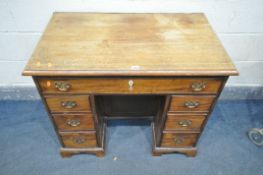 A GEORGIAN MAHOGANY KNEE HOLE DESK, with an assortment of seven drawers and a central cupboard door,