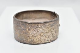 A WIDE SILVER HINGED BANGLE, with a scrolling foliate design, fitted with a push button integrated