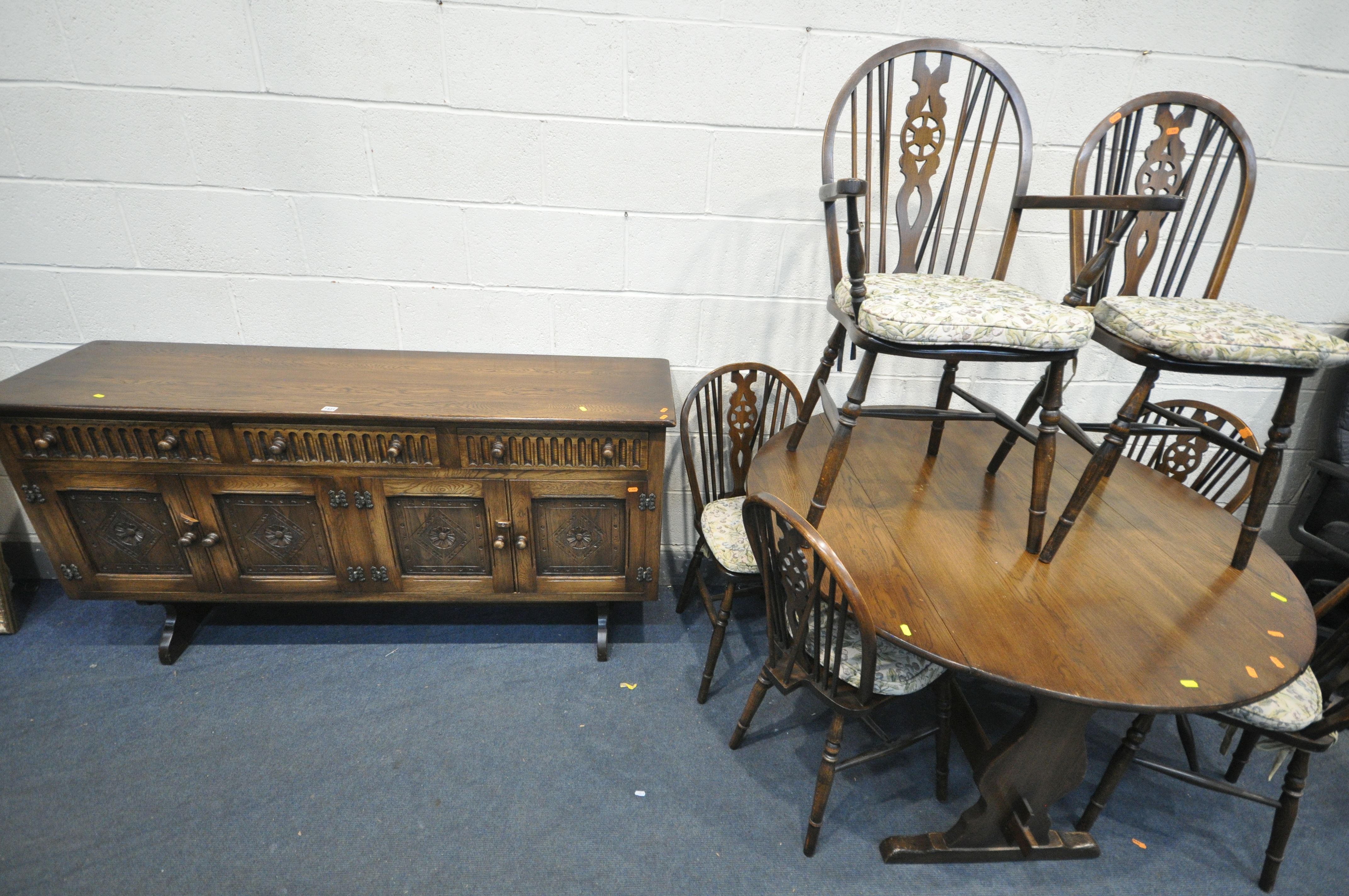 A 20TH CENTURY OAK CIRCULAR DROP LEAF TABLE, with trestle legs, united by a single stretcher,