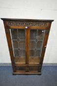 AN OLD CHARM OAK LEAD GLAZED TWO DOOR DISPLAY CABINET, with three internal shelves, and two small