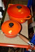 AN ORANGE LE CRUESET CASSEROLE AND SAUCEPAN, a circular covered casserole dish, diameter 23cm, a