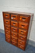 A SMALL 20TH CENTURY HARDWOOD BANK OF EIGHTEEN DRAWERS, with shell carved handles, width 54cm x