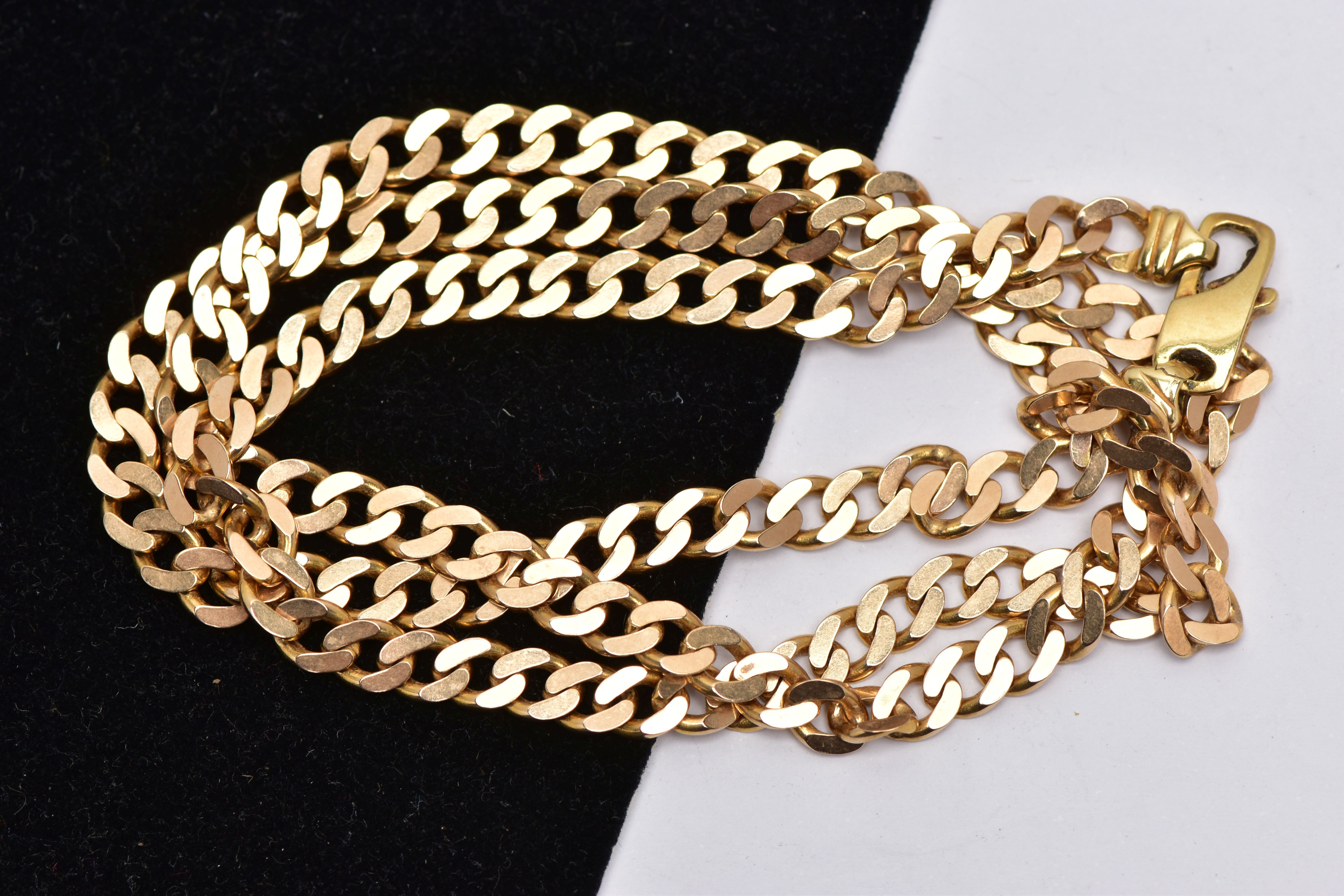 A YELLOW METAL NECKLACE, desiged as a flat curb link chain with lobster clasp, approximate length