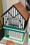 A MODERN WOODEN SHOP MODEL, modelled as a two storey half-timbered building with multi windowed shop