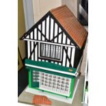 A MODERN WOODEN SHOP MODEL, modelled as a two storey half-timbered building with multi windowed shop