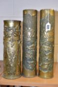 TRENCH ART, THREE SHELL CASES, comprising a pair of vases embossed with flowers and foliage, the