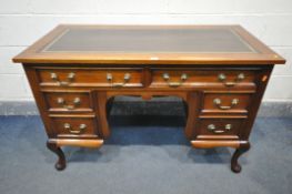 A 20TH CENTURY MAHOGANY KNEE HOLE DESK, with brown tooled leather inlay, an arrangement of six