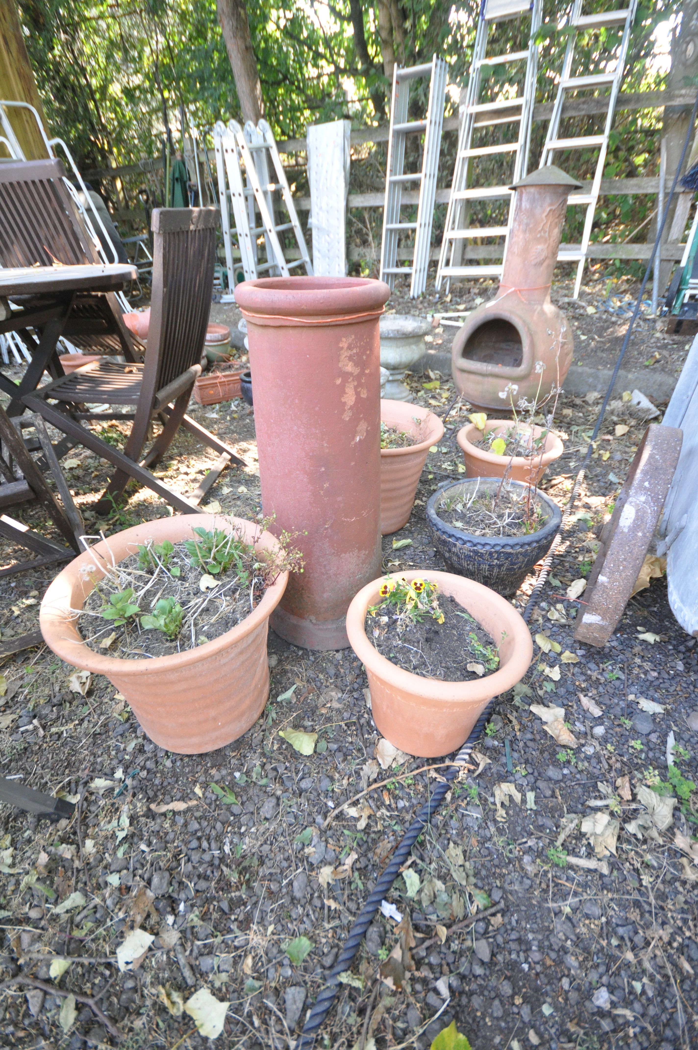 A CYLINDRICAL TERRACOTTA CHIMNEY POT, diameter 29cm x height 77cm, along with a pair of terracotta