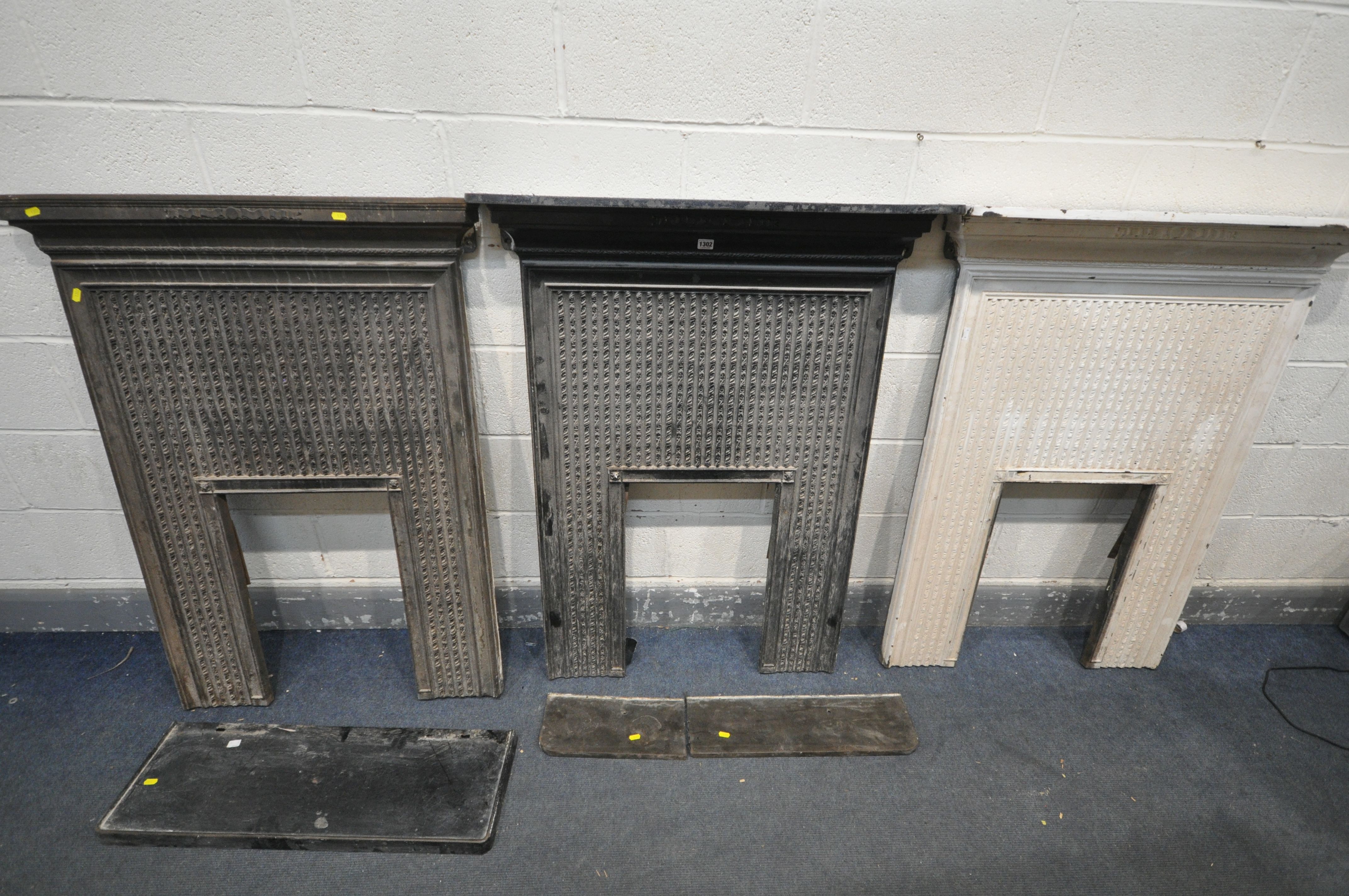 THREE CAST IRON FIRE SURROUNDS, two painted black, one painted white, width 91cm x depth 17cm x