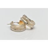 A PAIR OF WHITE METAL HOOP EARRINGS, each designed with grooved detailing, exposing a yellow metal