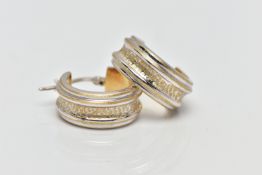 A PAIR OF WHITE METAL HOOP EARRINGS, each designed with grooved detailing, exposing a yellow metal