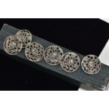 A SET OF SIX EARLY 20TH CENTURY SILVER BUTTONS, of circular pierced design, depicting a mythical