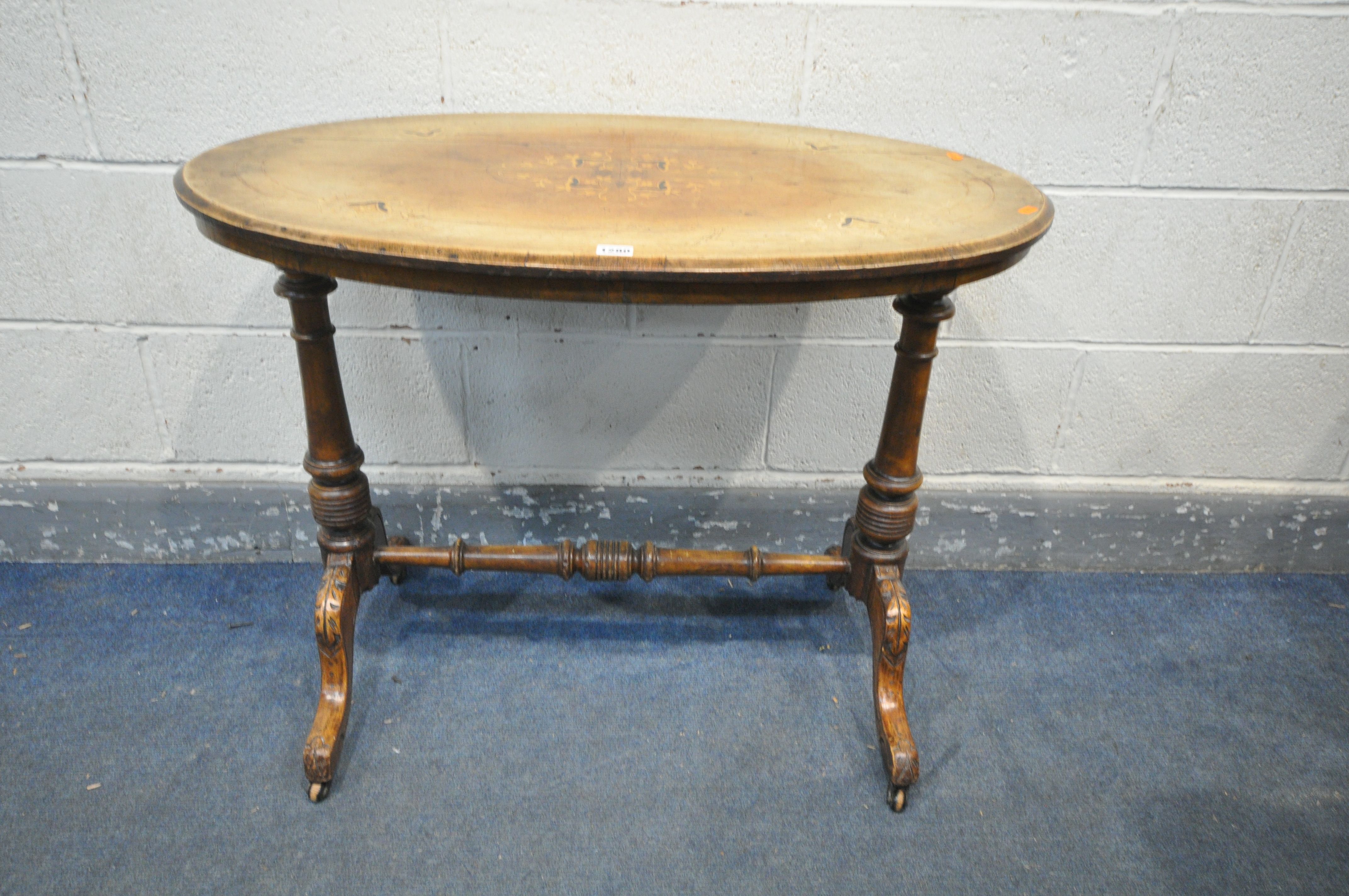 A VICTORIAN OVAL WALNUT CENTRE TABLE, with floral marquetry inlay, with turned supports, on carved