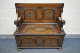 A CARVED OAK MONKS BENCH, with a retractable table top, and hinged storage compartment, on flat