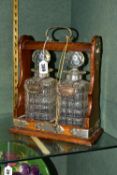 AN EARLY 20TH CENTURY OAK AND EPNS MOUNTED TWO DECANTER TANTALUS, locking / sprung mechanism to