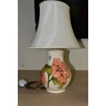 A MOORCROFT POTTERY TABLE LAMP BASE DECORATED WITH A CORAL 'HIBISCUS' DESIGN ON A CREAM