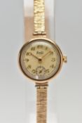 A LADIES 9CT GOLD WRISTWATCH WITH CHARM, hand wound movement, round discoloured dial signed 'Limit',