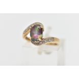 A 9CT GOLD GEM SET RING, designed with a four claw set, oval cut mystic coated topaz, curved cross