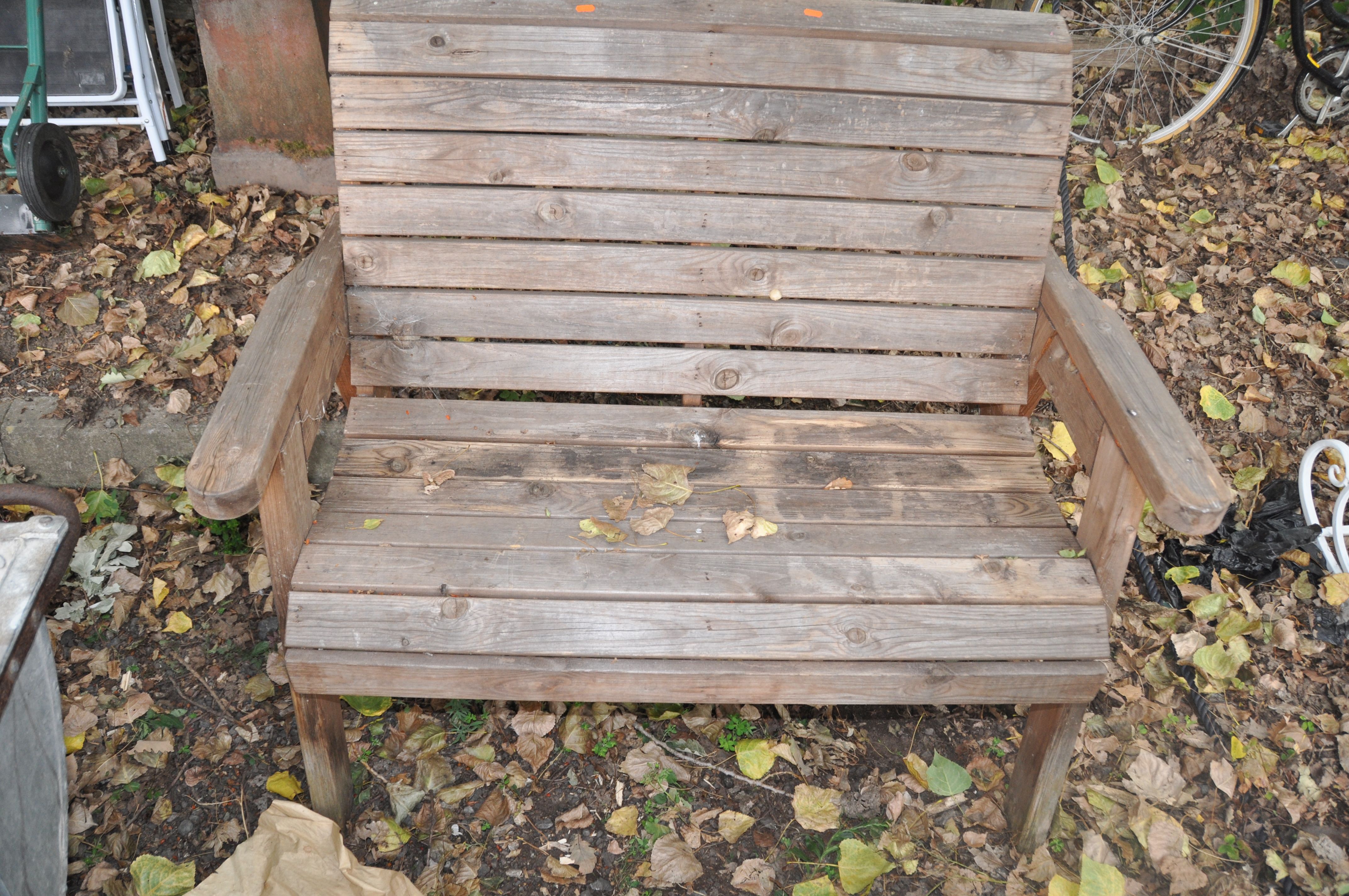 A MODERN PINE GARDEN BENCH with scrolled slatted seat and back 119cm wide