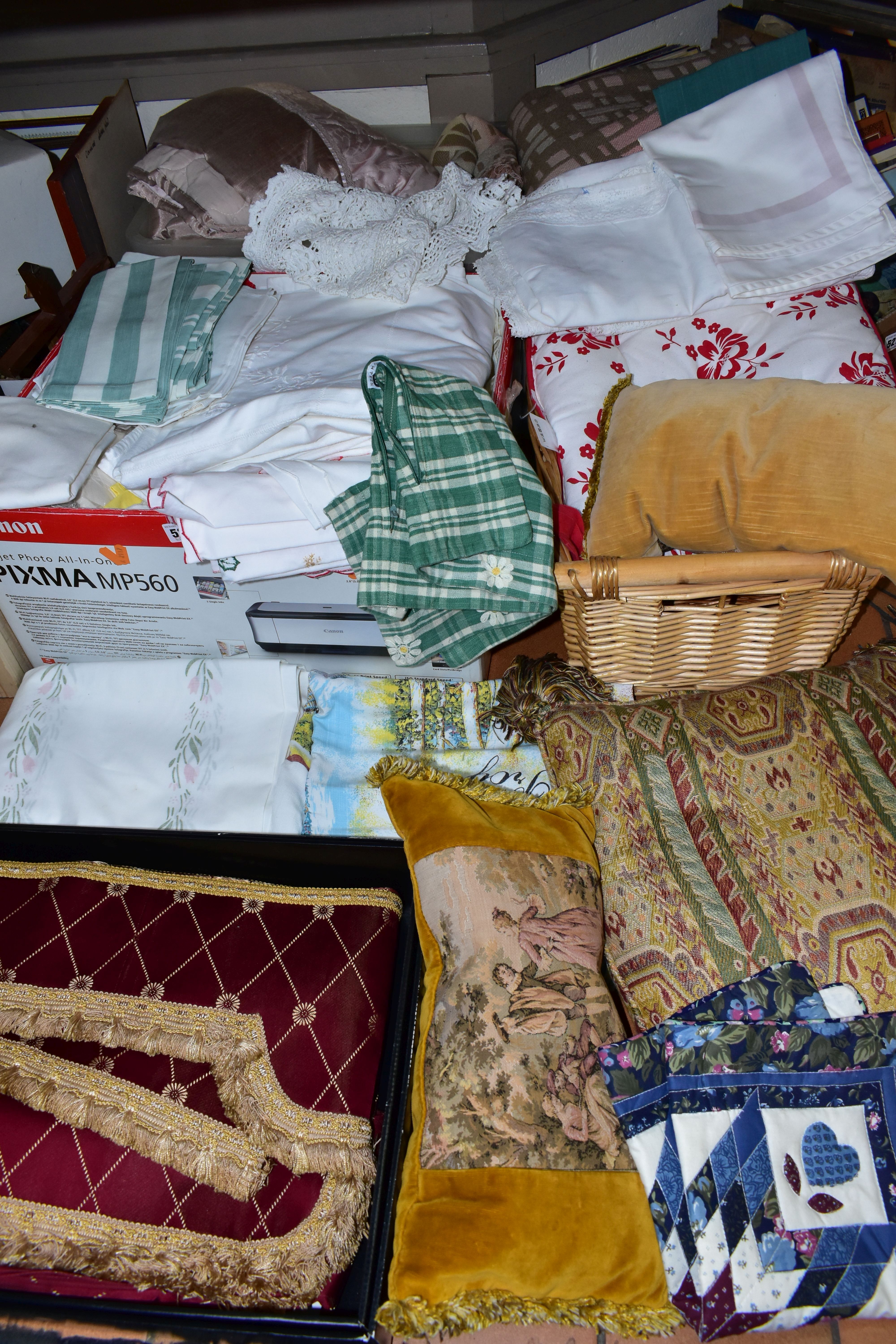 FOUR BOXES OF HOUSEHOLD LINENS, to include throws, cushions, cushion covers, tablecloths and