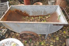 A VINTAGE METAL QUARRY/PIT TROLLEY with a galvanised half-moon bucket, cast iron wheels and rusted