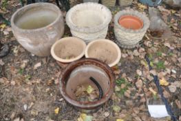 SIX COMPOSITE AND GLAZED GARDEN PLANT POTS the largest being 45cm in diameter, two with foliate