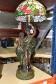 A TIFFANY STYLE LAMP, lamp base is of a young Grecian couple, the male figure is holding the shade