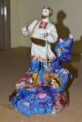 A KIEV PORCELAIN FIGURE OF 'SADKO', a folk tale adventurer and musician, playing music to the Sea