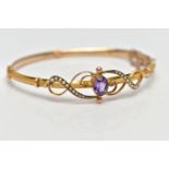 A YELLOW METAL AMETHYST AND SEED PEARL BANGLE, hollow hinged yellow metal knife edge bangle,