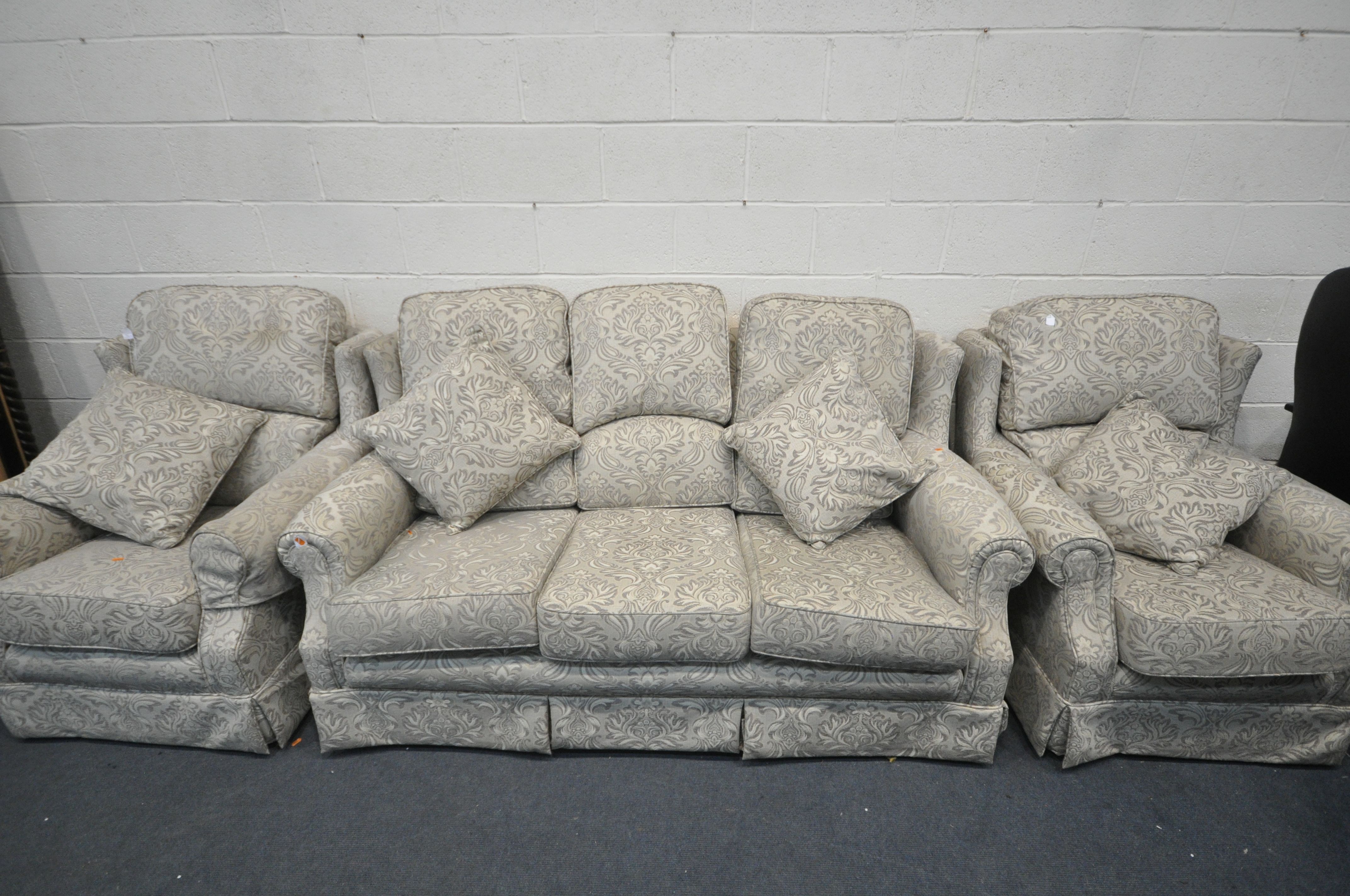 A FLORAL UPHOLSTERED THREE PIECE LOUNGE SUITE, comprising a three seater settee, and a pair of