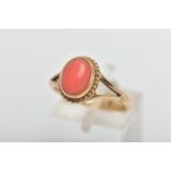 A 9CT GOLD CORAL DRESS RING, the oval coral cabochon, within a rope twist collet surround, measuring