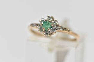 A 9CT GOLD EMERALD AND DIAMOND CLUSTER RING, set with a circular cut emerald, within a round