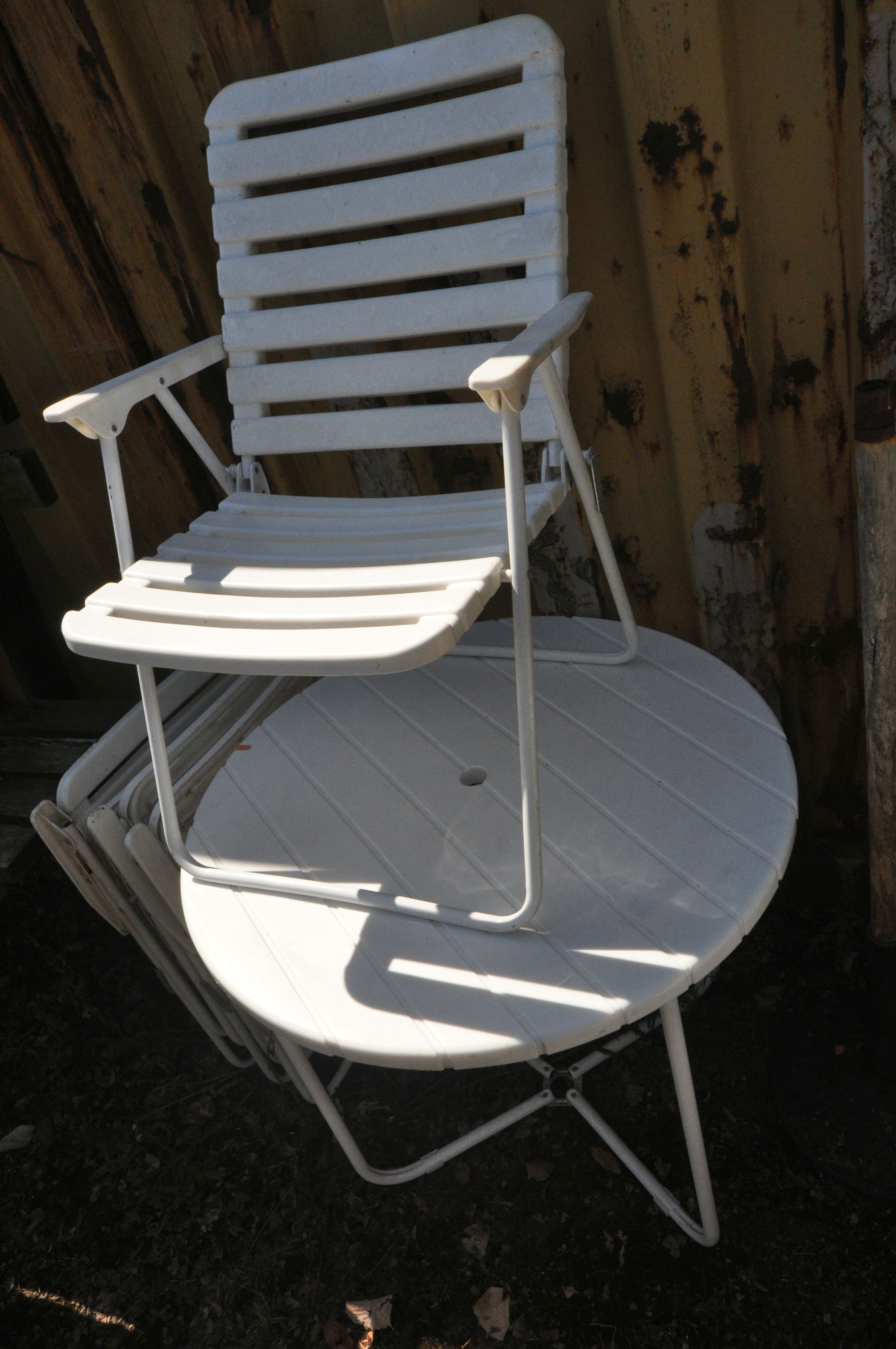 A TUBULAR METAL AND PLASTIC CIRCULAR FOLDING GARDEN TABLE, diameter 80cm x height 75cm, and four