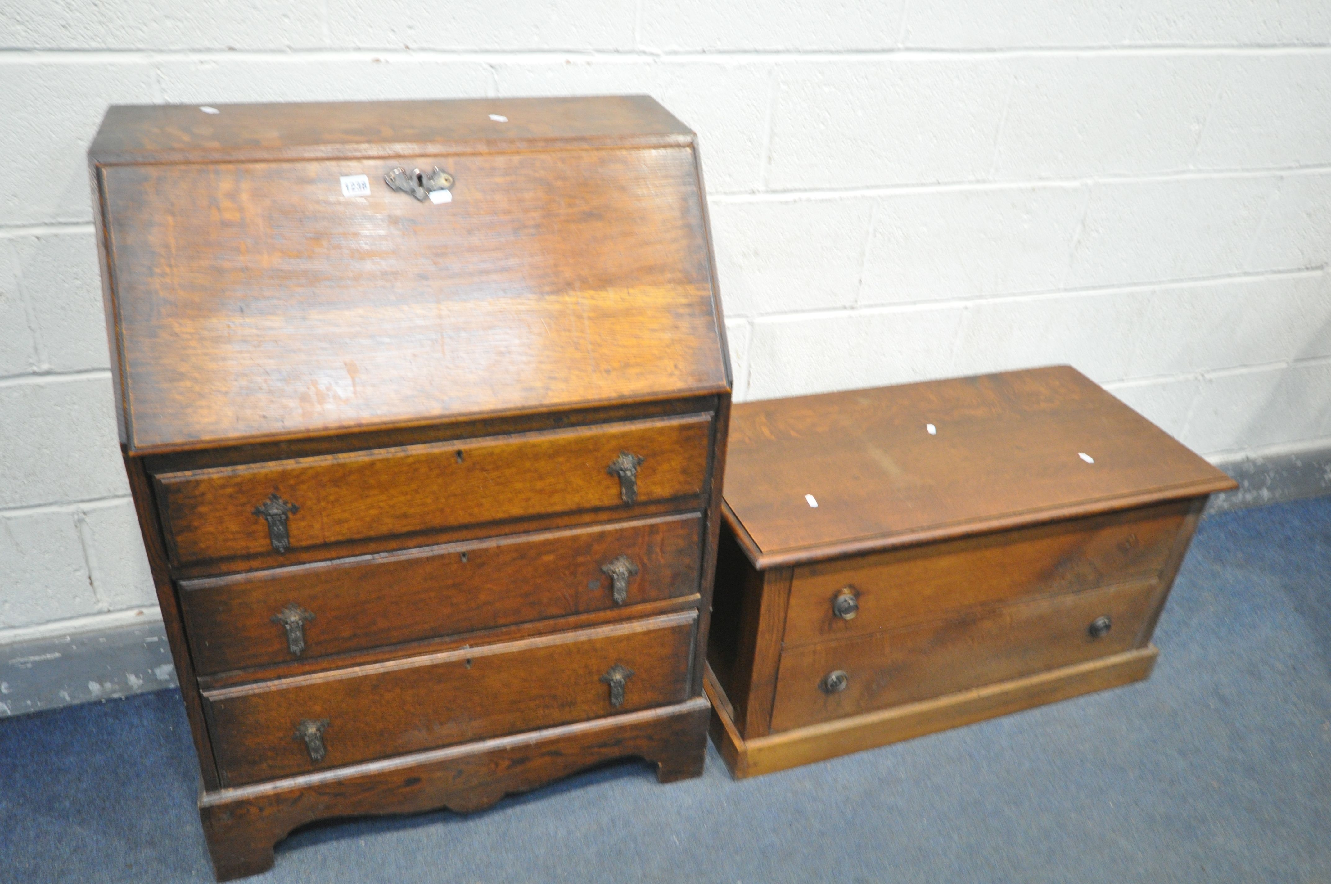 AN OAK FALL FRONT BUREAU, with fitted interior, above three graduated drawers, width 74cm x depth