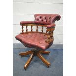 A BUTTONED OXBLOOD LEATHER SWIVEL OFFICE CHAIR (condition:-worn leather in places)