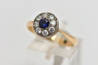 A GEMSET CLUSTER RING, set with a synthetic sapphire, surrounded by colourless paste, to the tapered