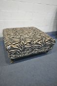A SQUARE ZEBRA PRINT UPHOLSTERED FOOSTOOL, on turned legs and brass casters, 104cm squared x