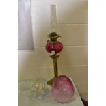 A LATE VICTORIAN OIL LAMP, the acid etched cranberry glass shade with broken section, cranberry