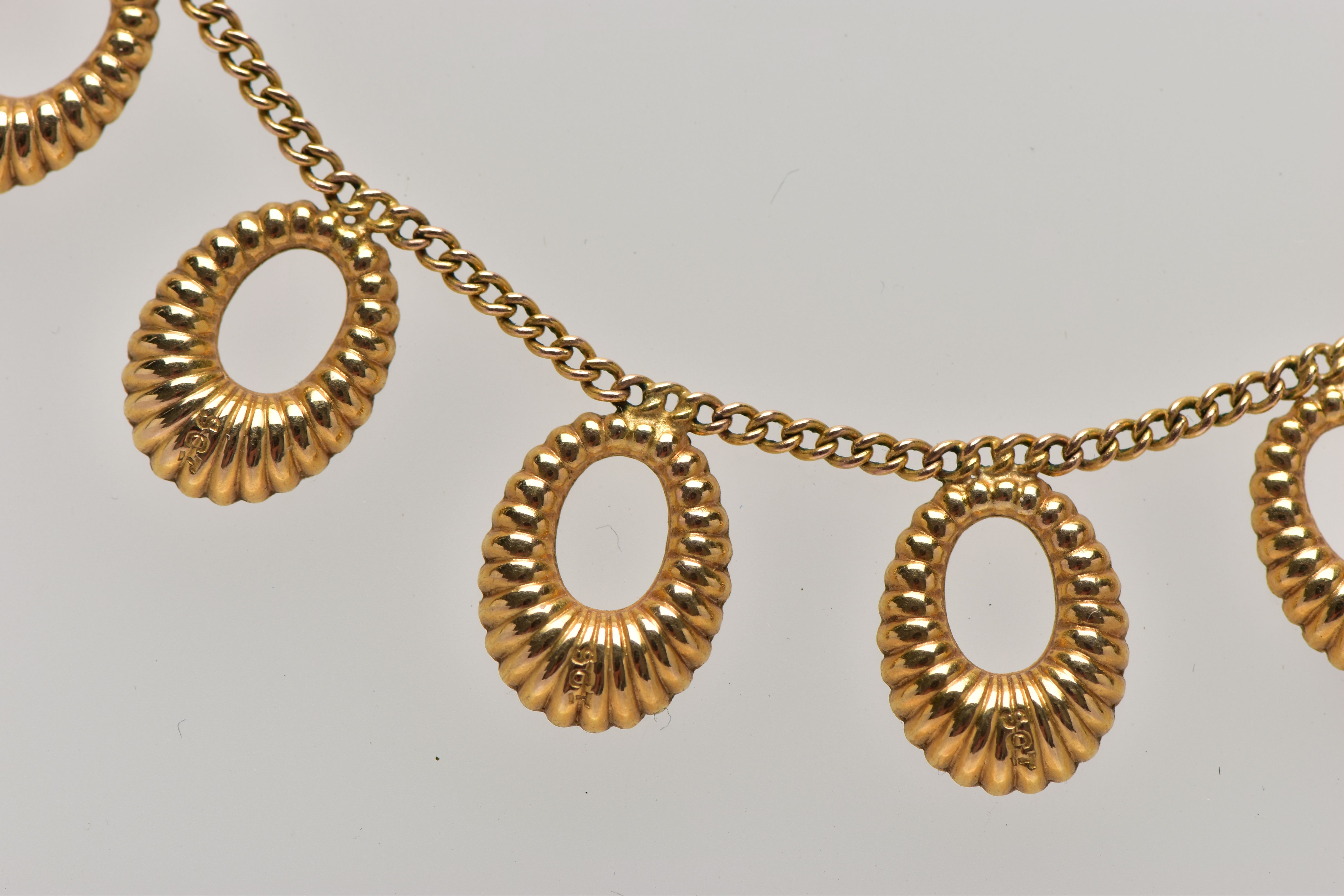 A YELLOW METAL FRINGE NECKLACE, comprising seven textured hoops, suspended from a flat curb link - Image 2 of 4
