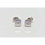 A PAIR OF WHITE METAL DIAMOND EARRINGS, the circular cut diamonds each set within a recess, to the