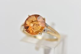 A 9CT GOLD GEM SET RING, four claw set, fancy circular cut orange stone assessed as citrine,