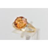 A 9CT GOLD GEM SET RING, four claw set, fancy circular cut orange stone assessed as citrine,