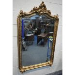 A LARGE GILT RESIN BEVELLED EDGE FRENCH WALL MIRROR, the top with foliate carving and detailing (