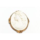 A YELLOW METAL LAVA CAMEO BROOCH, the cameo carved to depict a lady in profile with floral detail to