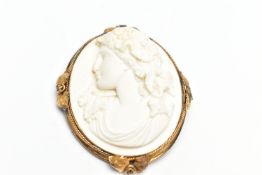 A YELLOW METAL LAVA CAMEO BROOCH, the cameo carved to depict a lady in profile with floral detail to