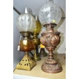 FOUR EARLY 20TH CENTURY OIL LAMPS, comprising a metal based lamp with hand painted flowers on a