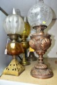 FOUR EARLY 20TH CENTURY OIL LAMPS, comprising a metal based lamp with hand painted flowers on a